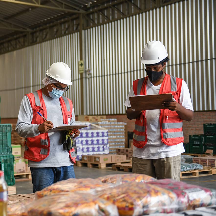 Staff from Banco de Alimentos Perú (BAP) review the inventory of food in the warehouse.
