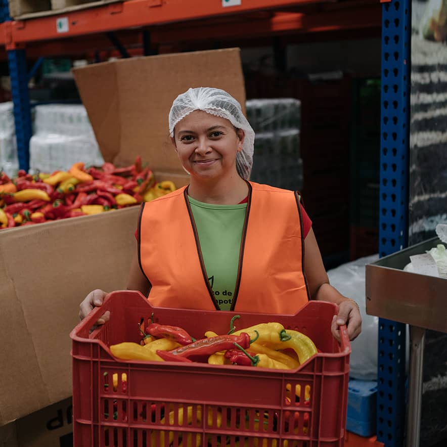 A volunteer at Bancos de Alimentos de México (BAMX) Zapotlanejo, organizes fresh produce in the warehouse.